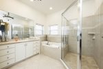 More space in the primary bathroom with glass door walk in shower and jacuzzi tub